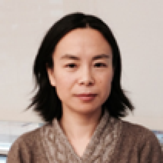 Liwen Zhang standing in front of an instrument