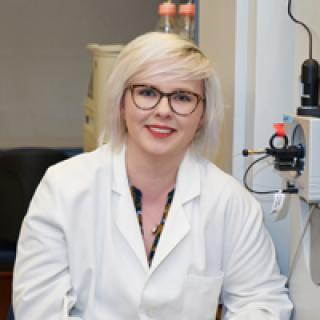 Sophie Harvey in the lab wearing a lab coat