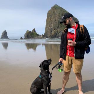Josh Gilbert on the beach with a dog